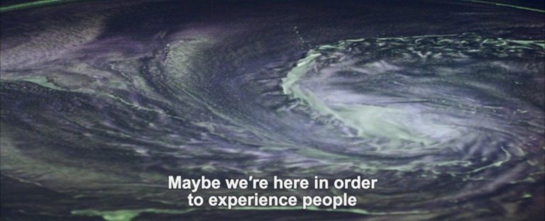 "Maybe we're here in order to experience people," subtitles read over a swirling cloud.